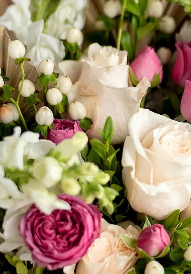Close-up of a bouquet of pink and white flowers, including white roses pink flowers and hypericum berries
